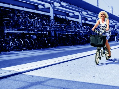 Frau auf einem Fahrrad vor einer Fahrradgarage am St. Pöltner Hauptbahnhof. (Foto: Robert Alexander Herbst)