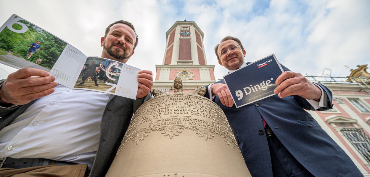 Zwei Personen mit Glocke vor dem Rathausturm. (Foto: Kalteis)