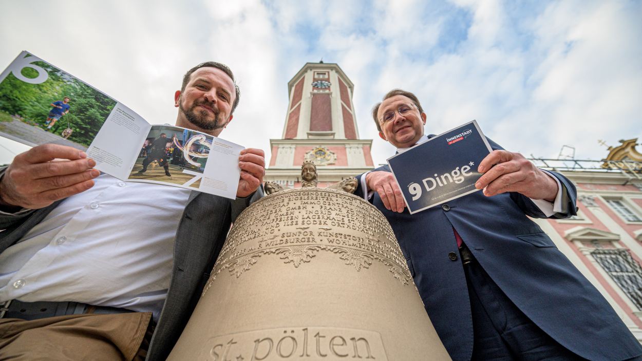 Zwei Personen mit Glocke vor dem Rathausturm. (Foto: Kalteis)