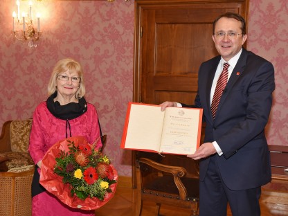 Bürgermeister Matthias Stadler hält Urkunde, Eva Riebler-Übleis hält einen Blumenstrauß. Beide stehend im Bürgermeisterzimmer. (Foto: Josef Vorlaufer)
