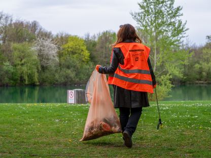 Frau am Ufer des Ratzersdorfer Sees beim Müllsammeln. (Foto: Christian Krückel)