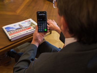 Bürgermeister Matthias Stadler mit dem gebundenen Rechnungsabschluss und einem Taschenrechner.