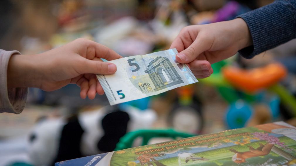 Ein Mädchen und ihre Mutter halten Spielzeug am Sparkassen-Flohmarkt in ihren Händen. Foto: Tanja Wagner