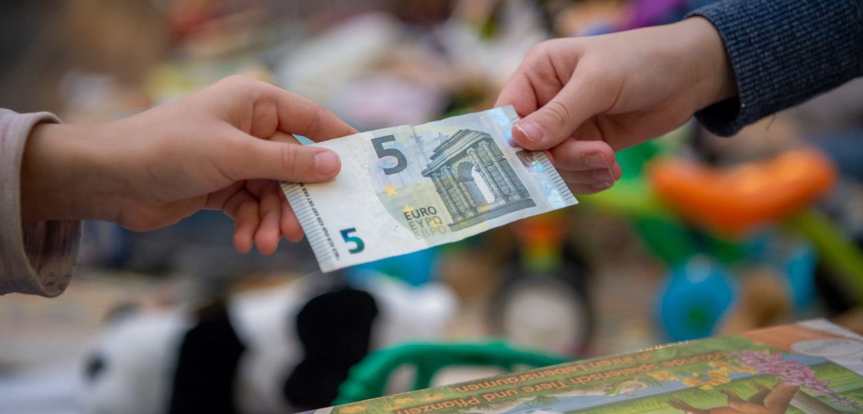 Ein Mädchen und ihre Mutter halten Spielzeug am Sparkassen-Flohmarkt in ihren Händen. Foto: Tanja Wagner