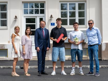 Ein Gruppenfoto der Mitarbeiterinnen der Immobilien St. Pölten GesmbH & Co KG gemeinsam mit Bürgermeister Matthias Stadler, dem Planer der Sanierung Roland Gronister von der gb-Projektmanagement GMBH sowie den neuen Bewohner:innen. (Foto: Gerald Weixelbraun)