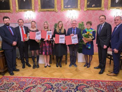 Neun Personen posieren für ein Gruppenfoto im Bürgermeisterzimmer bei der Preisverleihung. (Foto: Arman Kalteis)