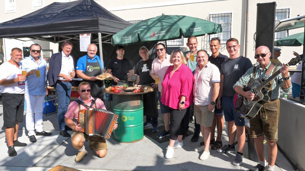 Einige Personen versammelt um einen Grill am Markt am St. Pöltner Domplatz. (Foto: Josef Vorlaufer)