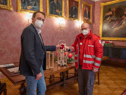 Bürgermeister Matthias Stadler und Sebastian Frank entzünden das Friedenslicht im Rathaus. (Foto: Arman Kalteis)