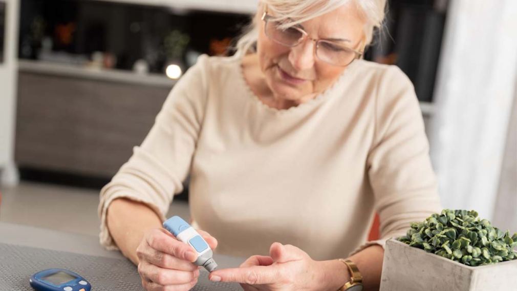Eine ältere Dame misst ihren Blutzuckerspiegel mit einem Gerät. (Foto: proxima studio)