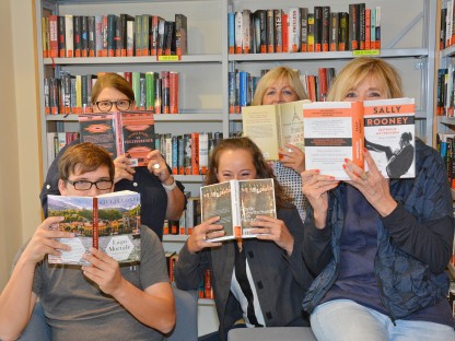 Fünf MitarbeiterInnen der Stadtbücherei verdecken ihren Mund mit Büchern. (Archivbild, Foto Medienservice)