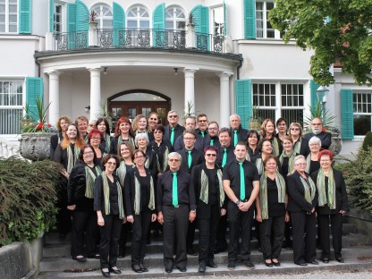 Der Stadtchor vor der Villa im Südpark. Alle sind in schwarz gekleidet. Die Männer tragen grüne Kravatten, die Frauen grüne Schals. (Foto: Stadtchor St. Pölten)