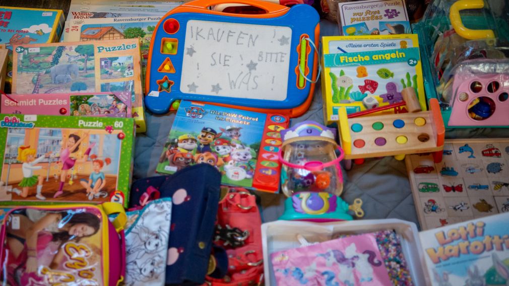 Ein Mädchen und ihre Mutter halten Spielzeug am Sparkassen-Flohmarkt in ihren Händen. Foto: Tanja Wagner