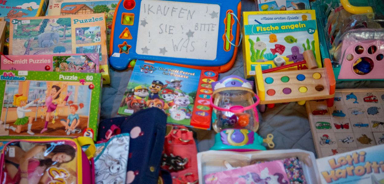 Ein Mädchen und ihre Mutter halten Spielzeug am Sparkassen-Flohmarkt in ihren Händen. Foto: Tanja Wagner