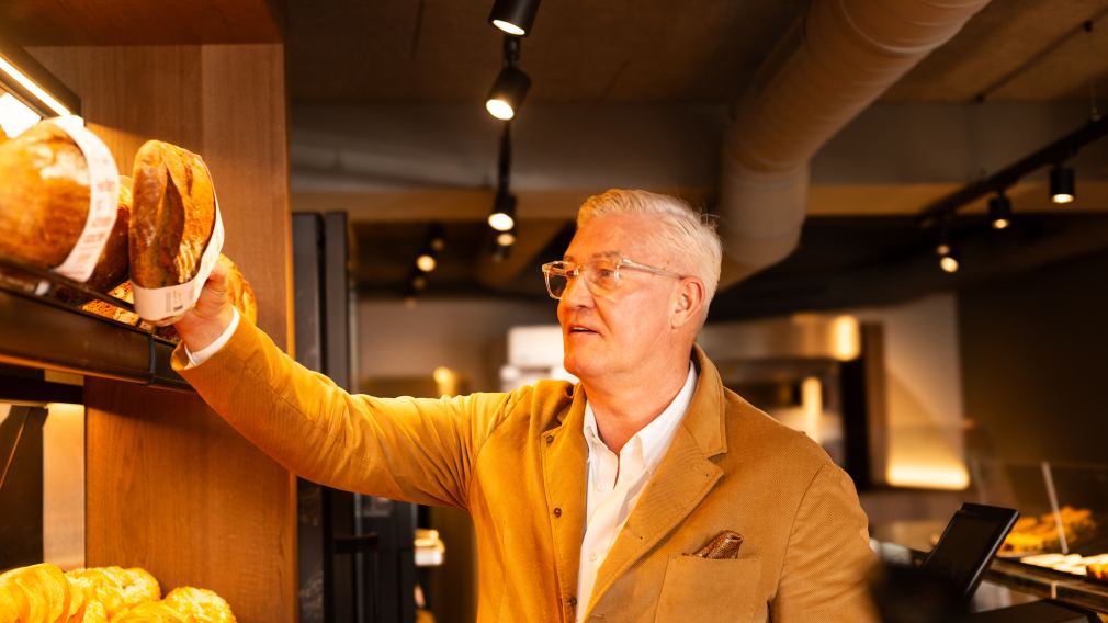 Wolfgang Hager greift ins Brotregal seiner Bäckerei Hager. Foto: Bäckerei Hager GmbH+KG