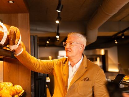 Wolfgang Hager greift ins Brotregal seiner Bäckerei Hager. Foto: Bäckerei Hager GmbH+KG