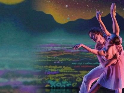 Ein Tänzer und eine Tänzerin führen auf einer Bühne ein Ballettestück vor.
