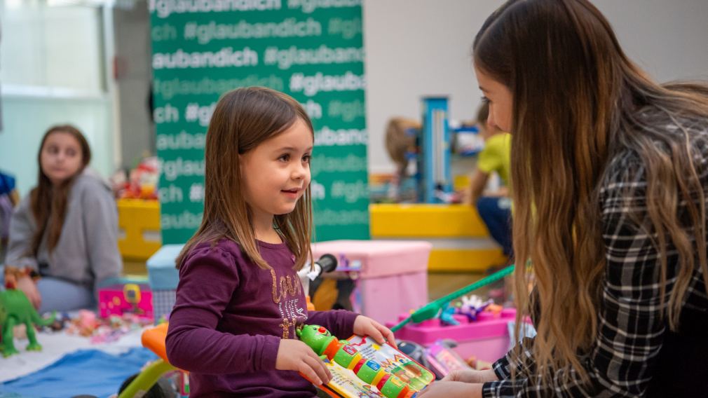 Ein Mädchen und ihre Mutter halten Spielzeug am Sparkassen-Flohmarkt in ihren Händen. Foto: Tanja Wagner