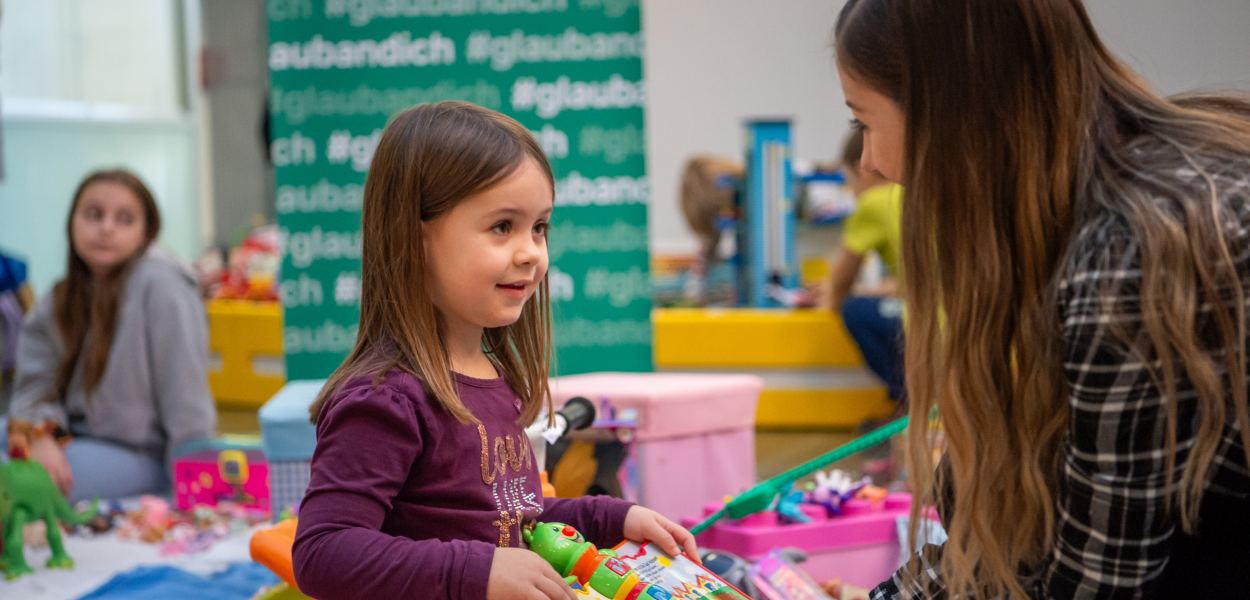 Ein Mädchen und ihre Mutter halten Spielzeug am Sparkassen-Flohmarkt in ihren Händen. Foto: Tanja Wagner