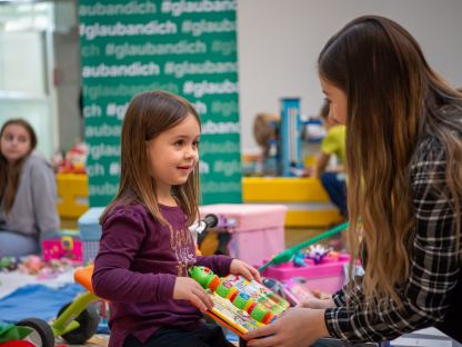 Ein Mädchen und ihre Mutter halten Spielzeug am Sparkassen-Flohmarkt in ihren Händen. Foto: Tanja Wagner